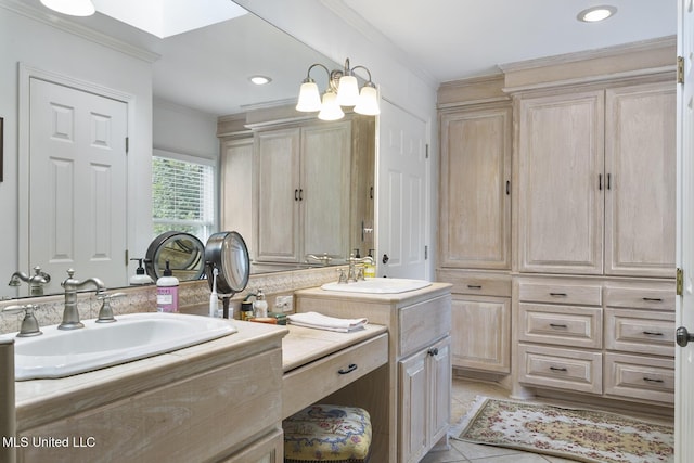 bathroom with a skylight, ornamental molding, vanity, a notable chandelier, and tile patterned flooring