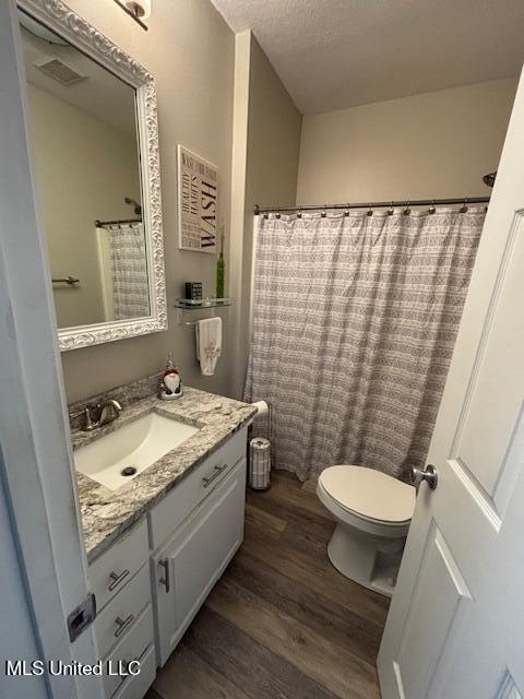 bathroom with vanity, hardwood / wood-style flooring, a textured ceiling, and toilet