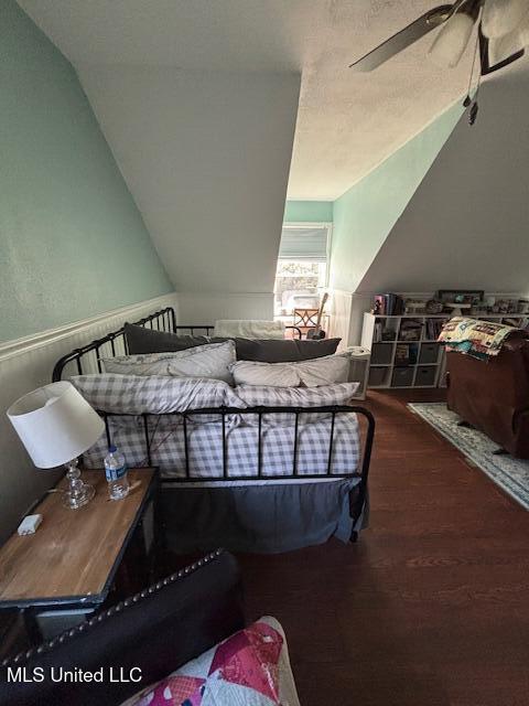 bedroom with wood-type flooring and vaulted ceiling