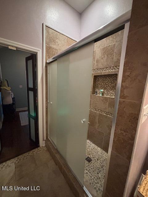 bathroom with a shower with door