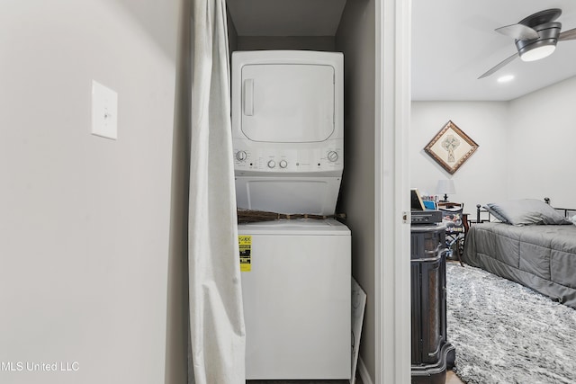 washroom featuring stacked washer / drying machine and ceiling fan