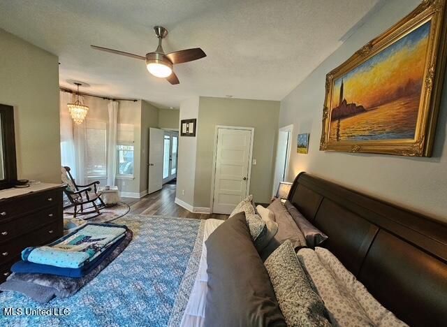 living room featuring wood-type flooring, a textured ceiling, and ceiling fan