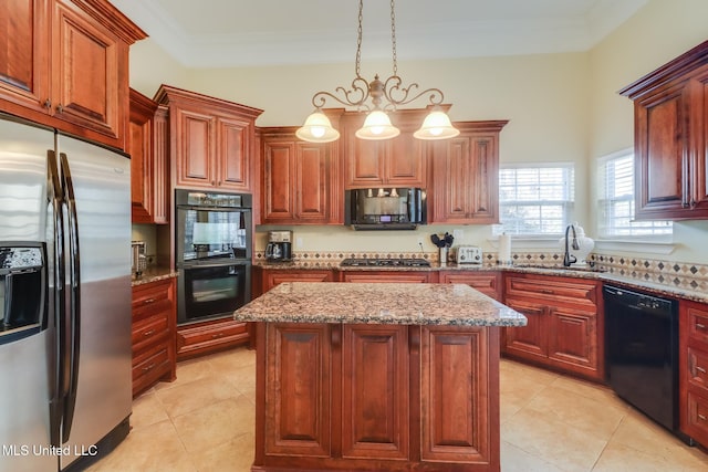 kitchen featuring a kitchen island, decorative light fixtures, light stone counters, and black appliances