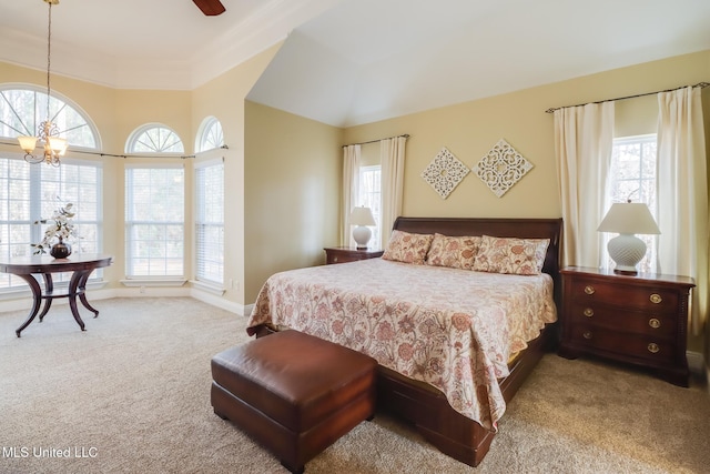 carpeted bedroom with ceiling fan with notable chandelier