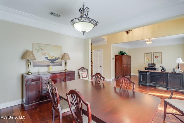 dining space featuring dark wood-type flooring and ornamental molding