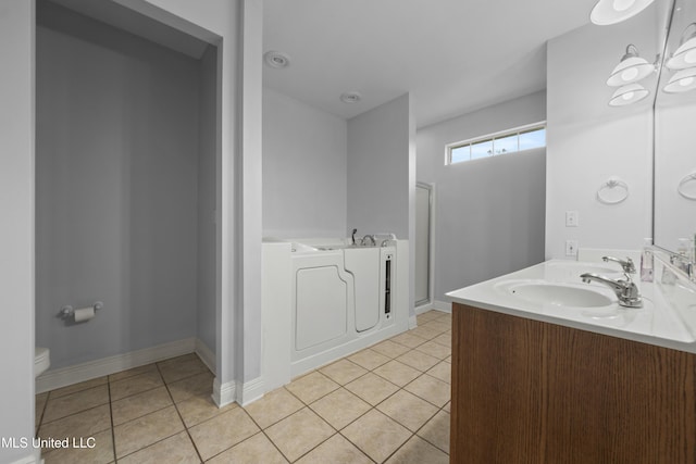 725 Old Savannah Dr, Long Beach, MS 39560 - bathroom featuring a bath, tile patterned floors, double vanity, toilet, and baseboards