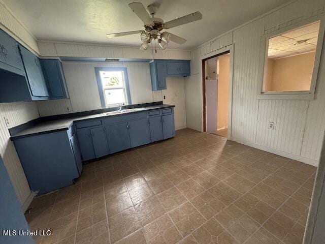 kitchen with blue cabinetry, ceiling fan, and a sink