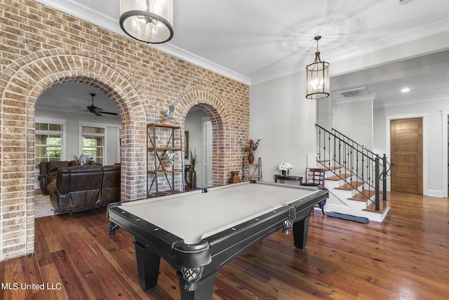 recreation room with dark wood-type flooring, brick wall, ornamental molding, and billiards