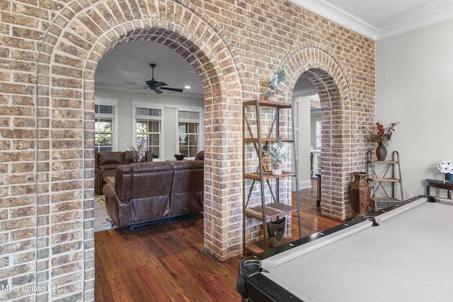 corridor featuring brick wall, crown molding, and dark hardwood / wood-style floors