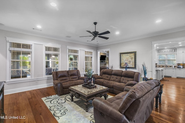 living room featuring ornamental molding, sink, dark wood-type flooring, and ceiling fan