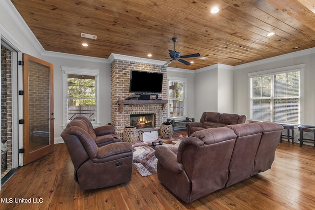 living room with hardwood / wood-style flooring, wooden ceiling, ornamental molding, and a brick fireplace