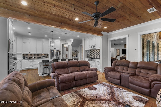 living room with wood ceiling, wood-type flooring, crown molding, and ceiling fan