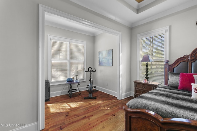 bedroom featuring multiple windows, hardwood / wood-style floors, and crown molding