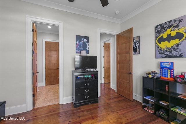 bedroom with dark wood-type flooring, ceiling fan, and ornamental molding