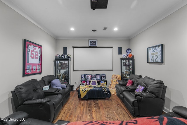 cinema room with wood-type flooring and ornamental molding