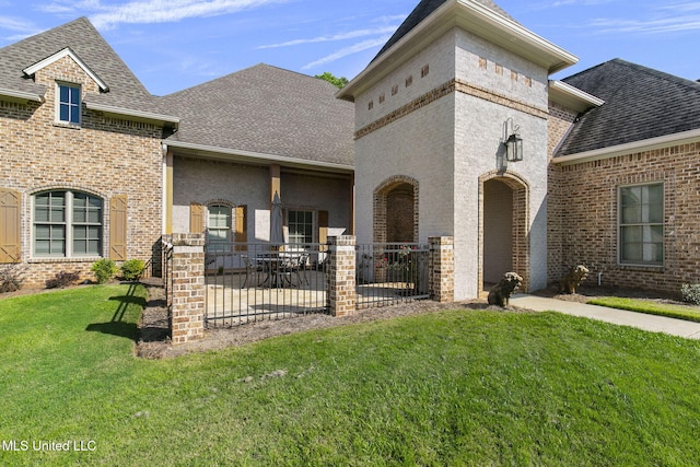 view of front facade with a patio and a front lawn