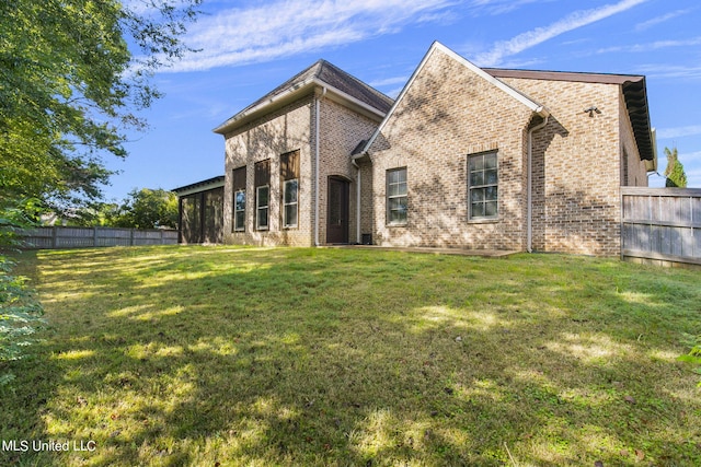 rear view of house featuring a lawn