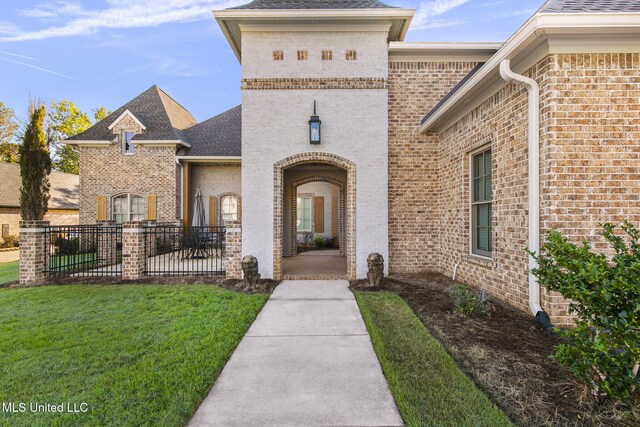 213 Ironwood Plantation Blvd, Madison, MS 39110 - doorway to property featuring fence, a shingled roof, brick siding, a patio, and a yard