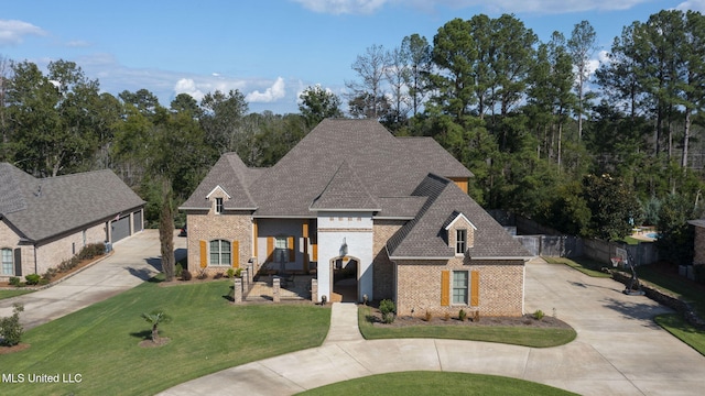 french country inspired facade with a front lawn and a garage