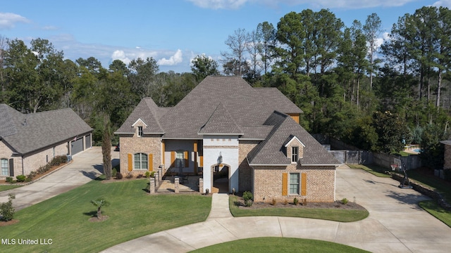 213 Ironwood Plantation Blvd, Madison, MS 39110 - french country inspired facade featuring roof with shingles, a front yard, driveway, and brick siding