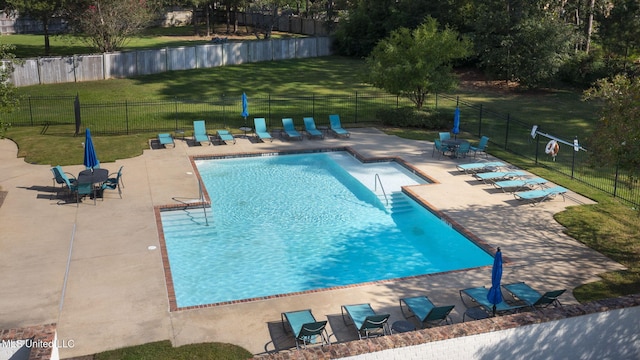 view of pool with a patio area and a lawn