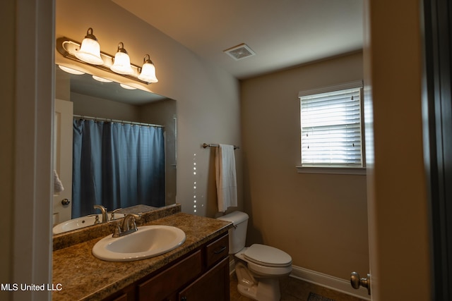 bathroom featuring tile patterned flooring, vanity, and toilet