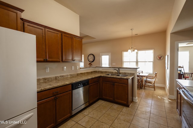 kitchen with pendant lighting, sink, kitchen peninsula, stainless steel appliances, and a chandelier