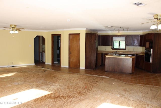 21481 Talmage Ln, Long Beach, MS 39560 - kitchen with a ceiling fan, a kitchen island, black oven, ornamental molding, and open floor plan