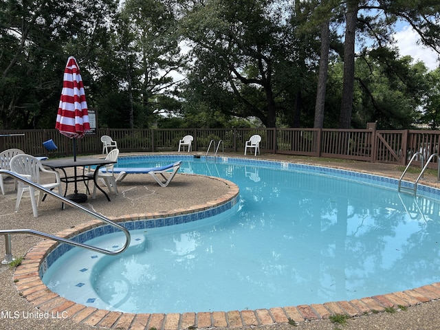 150 Lakeside Villa Unit J, Diamondhead, MS 39525 - community pool with a fenced backyard, a patio area, and view of wooded area