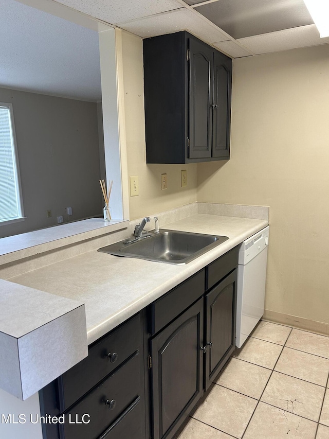150 Lakeside Villa Unit J, Diamondhead, MS 39525 - kitchen featuring white dishwasher, a sink, light tile patterned floors, light countertops, and baseboards
