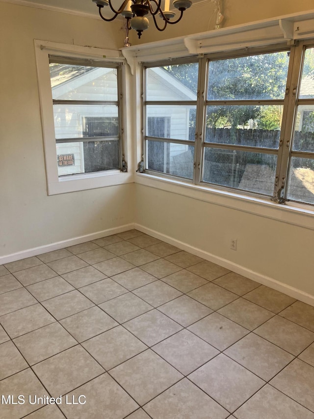 unfurnished room featuring a chandelier, light tile patterned floors, and baseboards