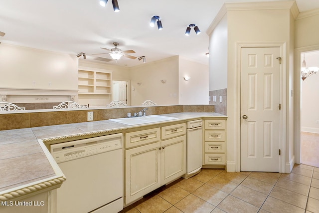 kitchen featuring light tile patterned floors, white dishwasher, ornamental molding, cream cabinetry, and sink