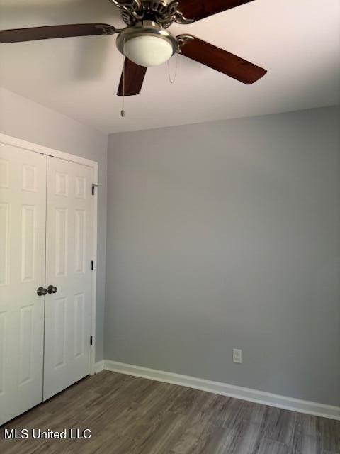 81 Hickory, Byhalia, MS 38611 - unfurnished bedroom featuring dark wood-style floors, a closet, and a ceiling fan