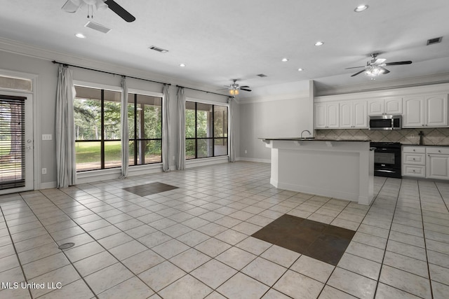 415 Spike Rdg, Canton, MS 39046 - kitchen with stainless steel microwave, black electric range oven, a ceiling fan, crown molding, and open floor plan