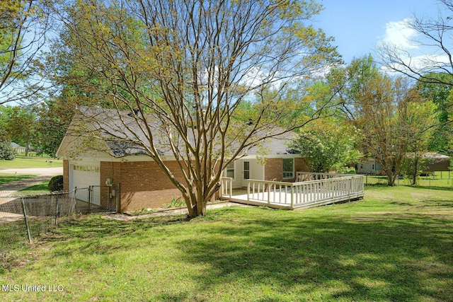 5415 Sollie Cv, Horn Lake, MS 38637 - back of property featuring driveway, fence, a yard, a wooden deck, and brick siding