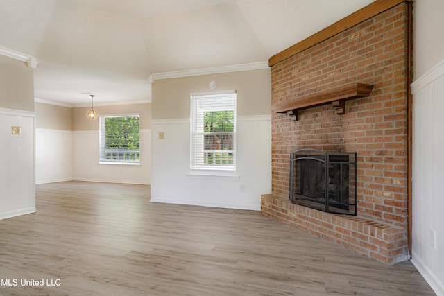 5415 Sollie Cv, Horn Lake, MS 38637 - unfurnished living room with a wainscoted wall, wood finished floors, vaulted ceiling, crown molding, and a brick fireplace