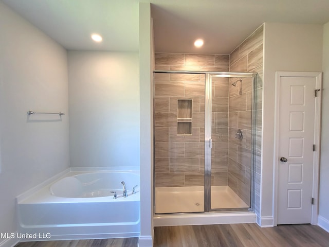 full bath featuring a garden tub, wood finished floors, and a shower stall