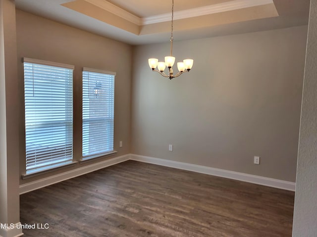 spare room with an inviting chandelier, a raised ceiling, dark wood-style floors, and baseboards