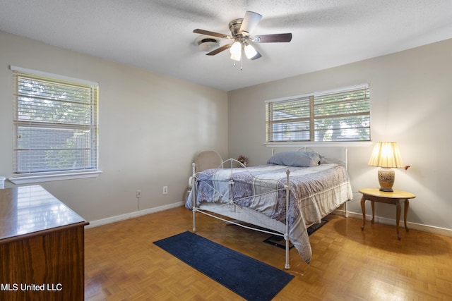 bedroom with baseboards, a ceiling fan, and a textured ceiling