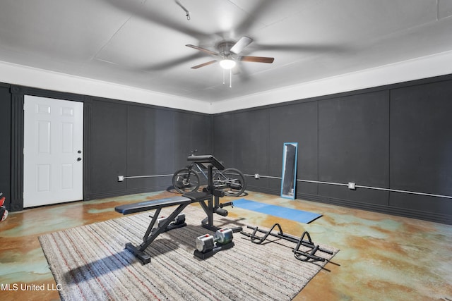 exercise area with ceiling fan and a decorative wall