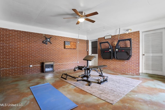 exercise area with a ceiling fan and brick wall