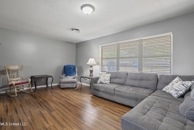 living area featuring baseboards, a textured ceiling, and wood finished floors