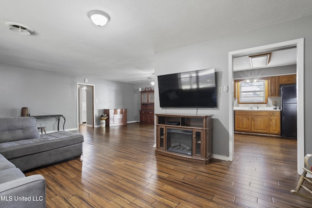 living area featuring baseboards and dark wood-type flooring