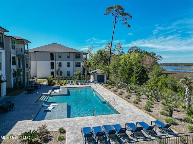 view of swimming pool featuring a patio area and a water view