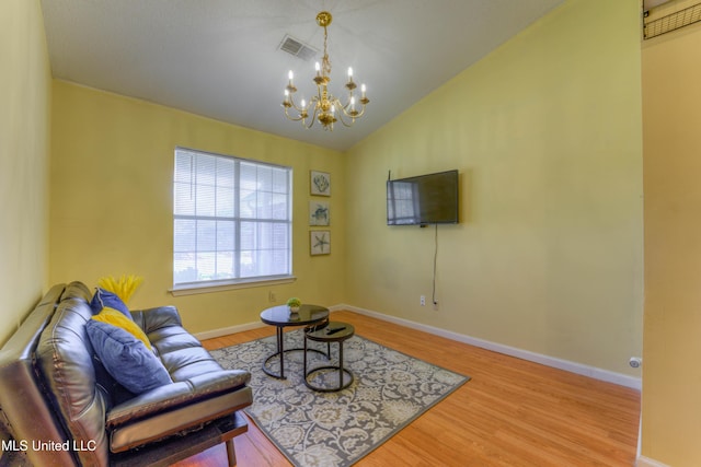 living room featuring an inviting chandelier, light wood-type flooring, and vaulted ceiling