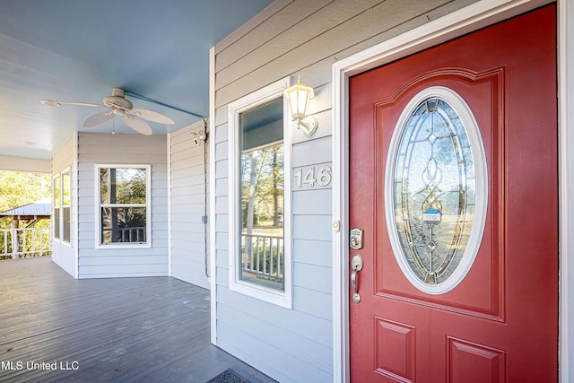 entrance to property with a porch and ceiling fan