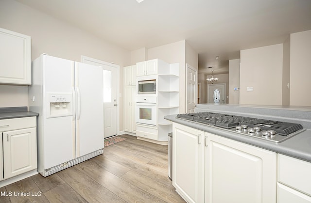 kitchen with a chandelier, appliances with stainless steel finishes, light hardwood / wood-style floors, and white cabinetry