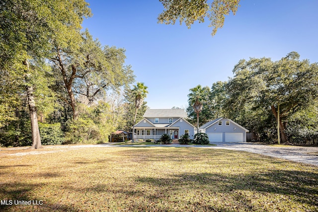 view of front facade featuring an outdoor structure, a front lawn, a porch, and a garage