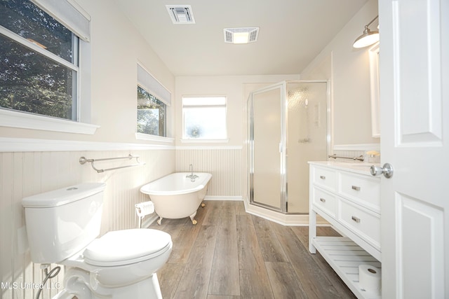 full bathroom with wood walls, toilet, vanity, independent shower and bath, and hardwood / wood-style flooring