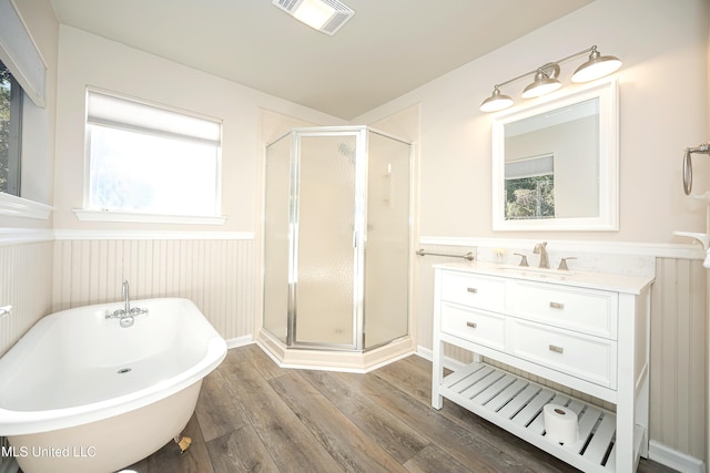 bathroom featuring wood-type flooring, plenty of natural light, and independent shower and bath